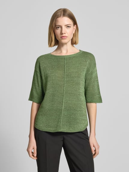 Frauenmodel trägt Relaxed Fit Pullover mit U-Boot-Ausschnitt von s.Oliver BLACK LABEL in schimmernder Optik, Strick, Mittelnaht, Label-Patch, Ganzkörperansicht von vorne.