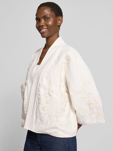 Frauenmodel trägt Jacke mit Stitchings Modell 'Rumi' von LOLLYS LAUNDRY aus Reiner Baumwolle in Regular-Fit, cremefarben mit strukturierter Oberfläche, Rückenlänge 60 cm, Schulterbreite 49 cm, Brustweite 61 cm, Ärmellänge 41 cm, Ganzkörperansicht von vorne.