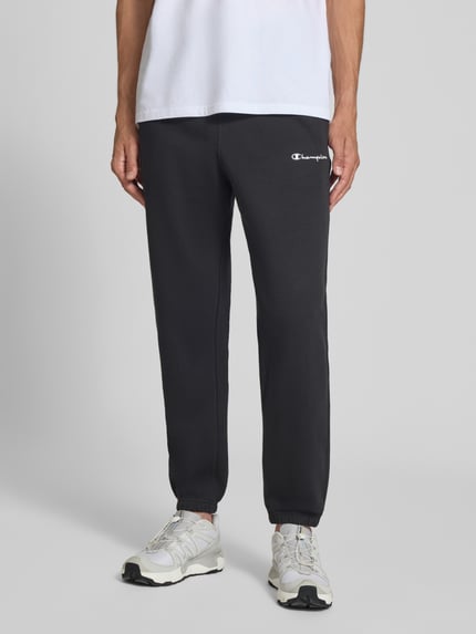 Mannenmodel draagt zwarte sweatpants met labelstitching Model 'ICONS' van Champion in katoenmix, recht model, steekzakken, elastische band, vooraanzicht volledige lengte