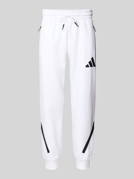 Produktfoto, Sweatpants mit elastischem Bund von adidas Sportswear in Weiß mit schwarzen Details, Baumwolle, lockerer Schnitt, Reißverschlusstaschen