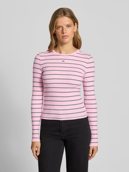 Frauenmodel trägt Slim Fit Langarmshirt aus Baumwoll-Mix von Tommy Jeans in Rosa mit schwarzen und weißen Streifen, Nahaufnahme Oberkörper, Damen Langarmshirt von Tommy Jeans.