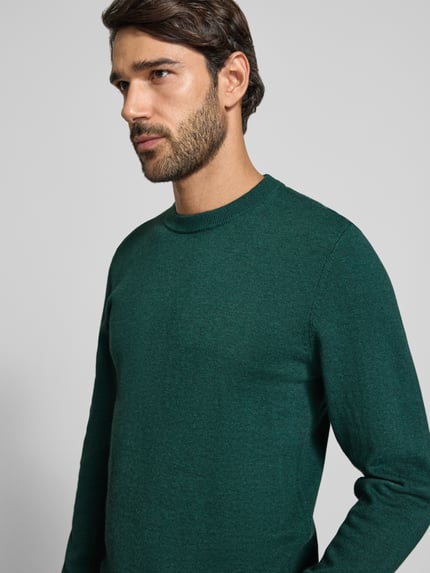 Männermodel trägt Strickpullover aus Baumwoll-Kaschmir-Mix mit Rundhalsausschnitt von MCNEAL in Dunkelgrün, Regular Fit, Nahaufnahme Oberkörper. Rückenlänge 70 cm, Ärmellänge 74 cm.