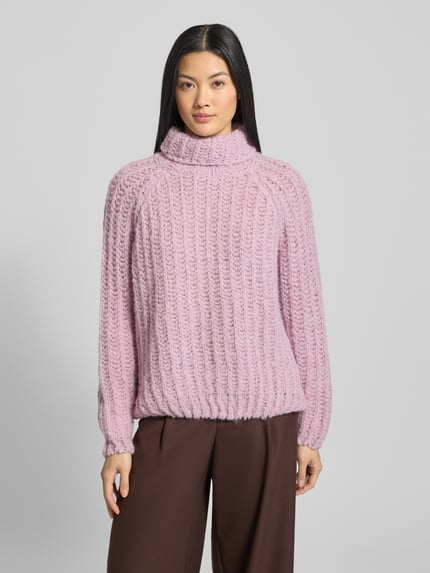 Modelka kobieca ma na sobie Strickpullover mit Rollkragen od Smith and Soul, luźny fason, fioletowy, prążkowana faktura, widok z przodu, kontekst: alpaka, długie rękawy, długość pleców 57 cm, długość rękawa 70 cm.