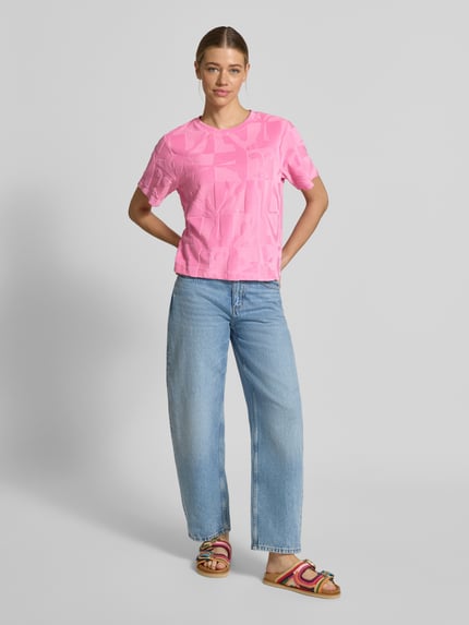 Modelka nosi T-Shirt im Allover-Look Modell 'NABI' od ICHI z mieszanki bawełny, krój regular fit, różowy wzór, okrągły dekolt, widok całej sylwetki z przodu.