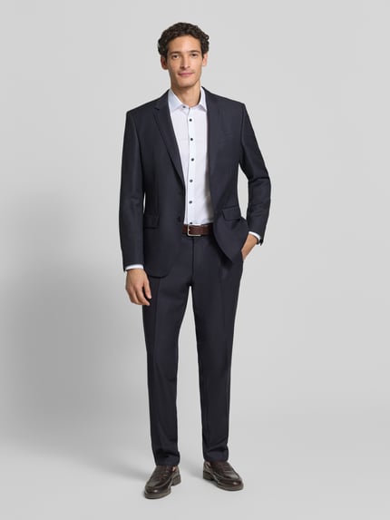 Männermodel trägt Slim Fit Businesshemd mit Kontrastkragen von OLYMP, feines Webmuster, Kentkragen, unifarben, Ganzkörperansicht von vorne.