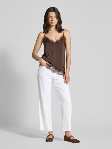 Frauenmodel trägt Wide Fit Jeans-Culotte aus Baumwoll-Mix Modell 'DREAM' von MAC in Weiß mit ausgefransten Beinabschlüssen, Ganzkörperansicht von vorne, elastischer Baumwoll-Modal-Mix, 5-Pocket-Design, verkürzte Passform, rückseitiges Label-Patch.
