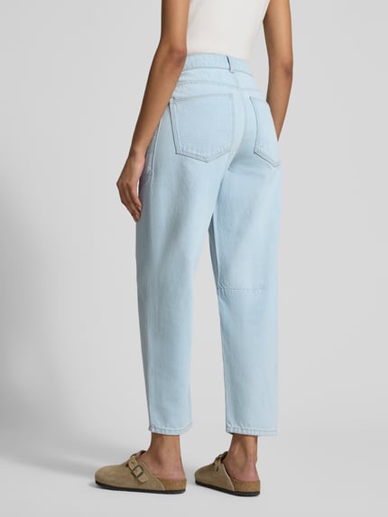 Młodzieżowy model nosi Barrel Fit Jeans mit aufgesetzten Taschen od Jake*s Casual z czystej bawełny, niebieskie, szerokie nogawki, szwy ozdobne, szerokość w rozmiarze 36: 38 cm, długość nogawki wewnętrznej w rozmiarze 36: 71 cm, widok całej sylwetki od tyłu.