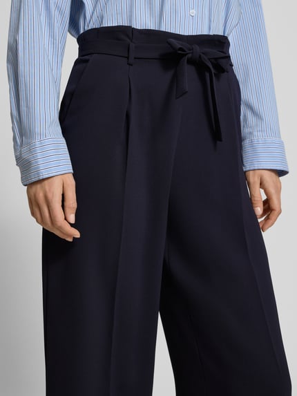 Frauenmodel trägt Regular Fit Stoffhose mit Gürtel von Windsor in Dunkelblau, Bügelfalten, Seitentaschen, Nahaufnahme Oberkörper.