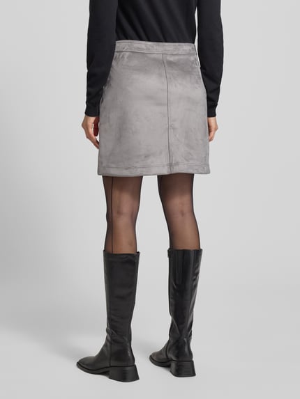 Frauenmodel trägt Minirock in Leder-Optik Modell 'Relvina cozy' von Opus, grauer Material-Mix, gerader Schnitt, Rückansicht Ganzkörperansicht.