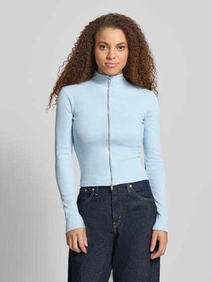 Frauenmodel trägt Slim Fit Jacke mit Stehkragen von Gina Tricot, hellblau, Baumwoll-Mix, Zweiwege-Reißverschluss, Ganzkörperansicht von vorne.
