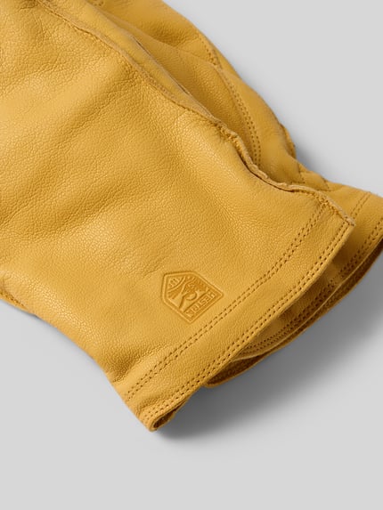 Productfoto, gele Handschoenen van echt leer van Hestra, model 'Jon', fijne nerfstructuur, labeldetail, context: heren handschoenen.
