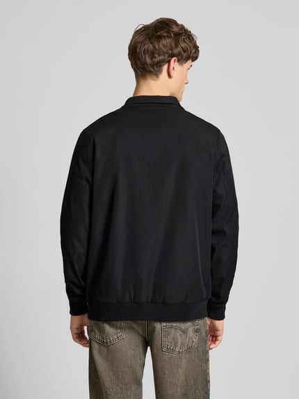 Männermodel trägt Regular Fit Jacke mit Stehkragen Modell 'Hefi' von Blend in Schwarz, reine Baumwolle, Rückansicht, Ganzkörperansicht.