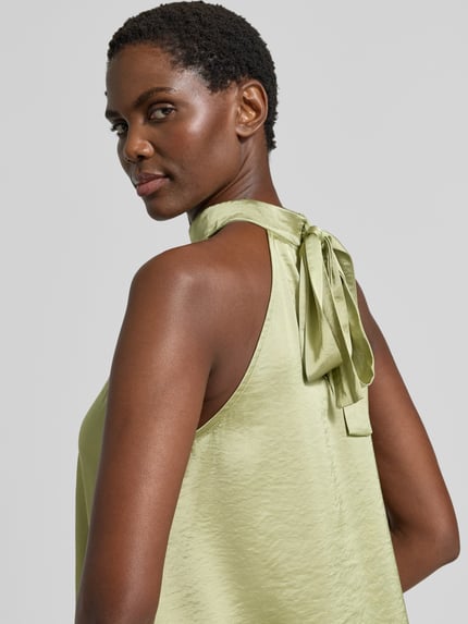 Vrouwenmodel draagt Blusentop aus Satin mit Viskose-Anteil van mbyM, lichtgroen, satijnstructuur, Materiaalmix met viscose, opstaande kraag, knoopsluiting achter, los model, Ruglengte maat S 56 cm, detailopname schouder en rug.