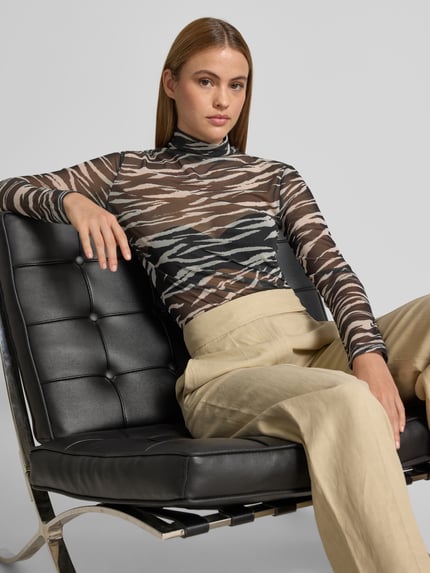 Frauenmodel trägt Longsleeve im semitransparenten Design von Lala Berlin, Elastischer-Material-Mix, Slim-Fit, Allover-Animal-Print, Stehkragen, Beige und Schwarz, Ganzkörperansicht von vorne.