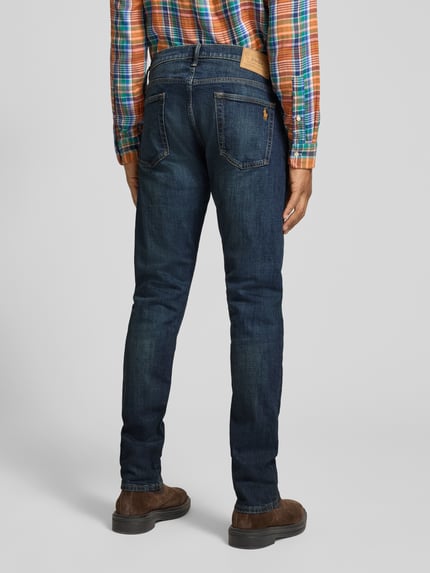 Männermodel trägt Slim Fit Jeans mit Used Waschung von POLO RALPH LAUREN in Medium Wash, 5-Pocket-Design, Rückansicht Ganzkörperansicht.