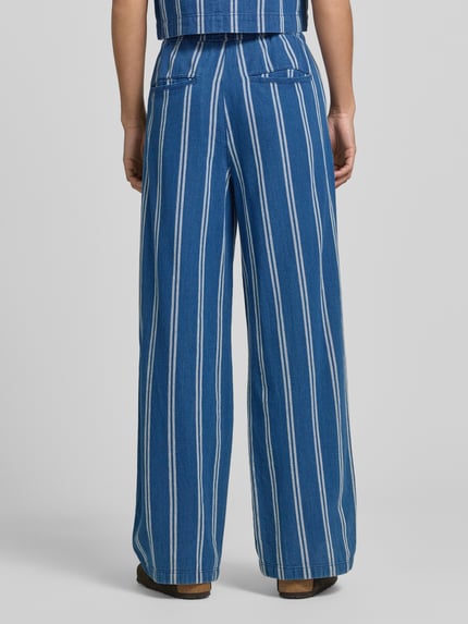 Frauenmodel trägt Wide-Leg-Pants mit elastischem Bund und Kordelzug von Jake*s Casual aus reiner Baumwolle, ausgestellter Schnitt, blaue Grundfarbe mit weißen Streifen, französische Eingrifftaschen und Gesäßtaschen, Produktdetails zu Bundweite und Innenbeinlänge, Ganzkörperansicht Rückansicht.