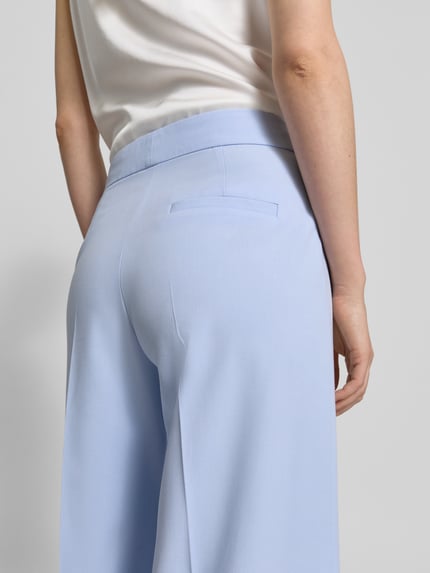 Frauenmodel trägt Flare-Fit Weite HOSE mit Viskose-Anteil Modell 'HUZILI' von HUGO, Optik: Unifarben, Materialverarbeitung: Twill, Detailaufnahme Rückansicht.