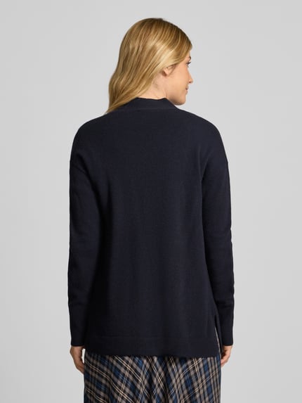 Frauenmodel trägt Strickjacke in offener Passform von Christian Berg Woman, reine Baumwolle, Regular Fit, gerippte Abschlüsse, Rückenansicht Ganzkörperansicht.