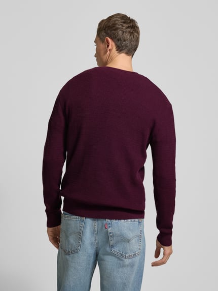 Männermodel trägt Strickpullover mit gerippten Abschlüssen von CK Calvin Klein in Dunkellila, Baumwoll-Mix mit Stretch-Anteil, Regular-Fit, Ganzkörperansicht Rückansicht.