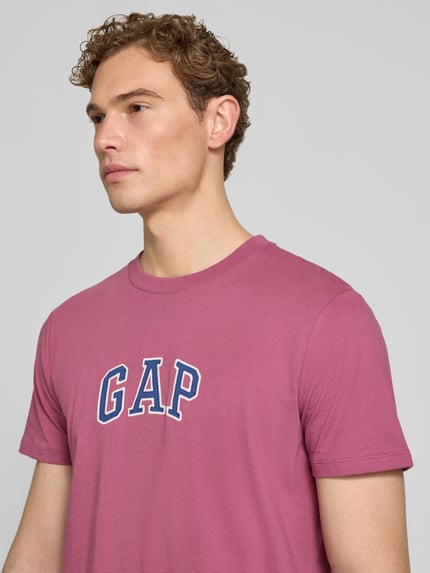Männermodel trägt T-Shirt mit Logo-Patch und Rundhalsausschnitt von GAP in Pink, reine Baumwolle, Straight Fit, Nahaufnahme Oberkörper.