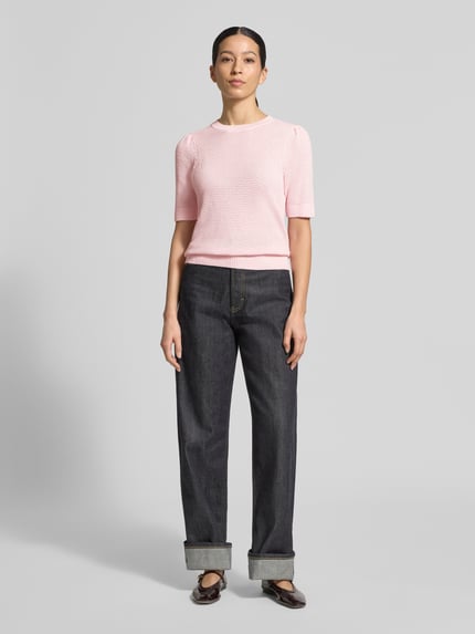 Frauenmodel trägt Slim Fit T-Shirt in Strick-Optik Modell 'Vidalo' von Vila, reine Baumwolle, rosa, Rundhalsausschnitt, Ganzkörperansicht von vorne.