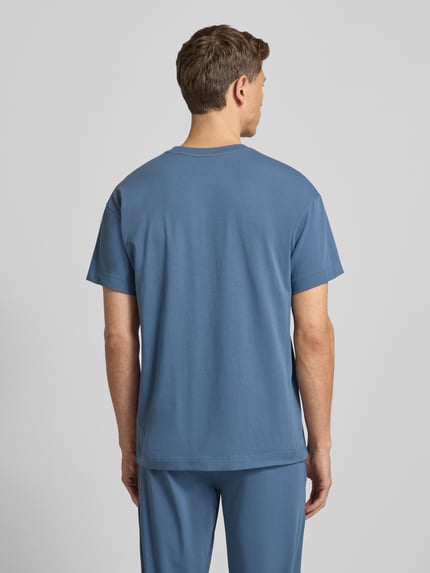 Männermodel trägt Regular Fit T-Shirt aus Baumwoll-Mix Modell 'LAZE T-SHIRT' von HUGO in Uni-Blau, Sweat-Textur, Ganzkörperansicht Rückansicht.