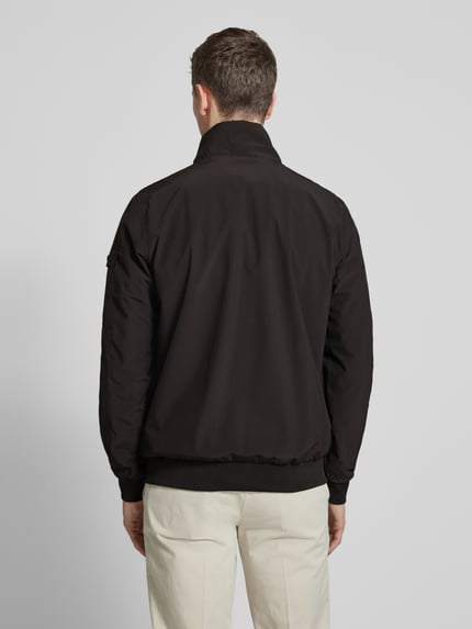 Männermodel trägt schwarzen Windbreaker mit Stehkragen Modell 'YETUR' von CARS JEANS, glatte Struktur, Ganzkörperansicht Rückansicht.