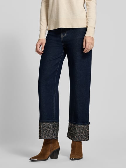 Frauenmodel trägt Straight Fit Jeans mit Umschlag und Ziersteinbesatz von miss goodlife aus dunklem Baumwoll-Mix mit Stretch-Anteil, Nahaufnahme Unterkörper.