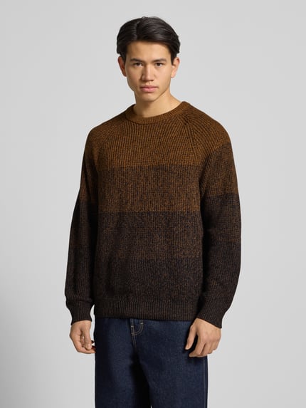 Männermodel trägt Relaxed Fit Strickpullover aus reiner Baumwolle Modell 'BIRK' von Only & Sons, melange Ombré-Muster, Ganzkörperansicht von vorne.