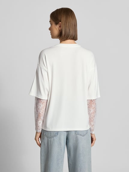Frauenmodel trägt Regular Fit Langarmshirt mit Viskose-Anteil Modell 'TAHLIA' von ONLY, Weiß, Spitzendetails, Damen Langarmshirt, Ganzkörperansicht Rückansicht.