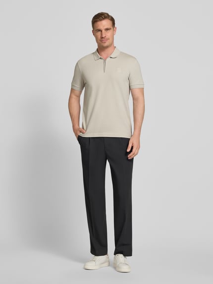 Männermodel trägt Slim Fit Poloshirt aus Baumwoll-Mix Modell 'PASSERZIP' von BOSS Orange, Optik: Unifarben, Ganzkörperansicht von vorne.