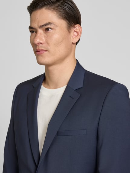 Männermodel trägt dunkelblauen Super Slim Fit Anzug aus Woll-Mix Modell 'ARTI/HESTEN' von HUGO, unifarben, Nahaufnahme Oberkörper.