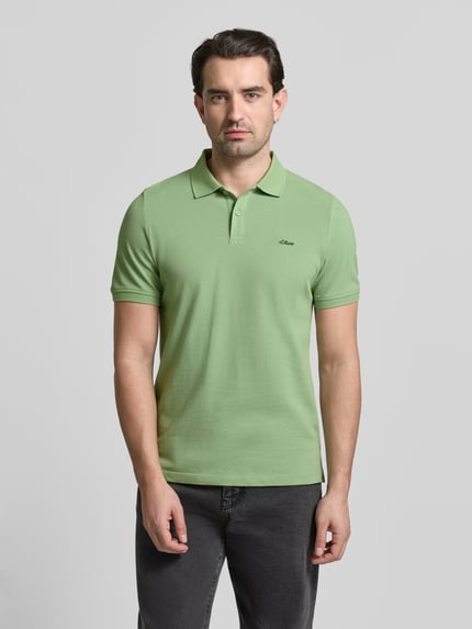 Męski model nosi Regular Fit Poloshirt aus reiner Baumwolle od s.Oliver RED LABEL, jednolity kolor, krój regular fit, krótki rękaw, materiał piké, bawełna, widok całej sylwetki z przodu.