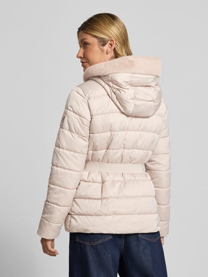 Frauenmodel trägt Steppjacke mit Reißverschlusstaschen und Gürtel von monari in zartem Rosé mit Kapuze und Gürtel, Rückenansicht, Ganzkörperansicht Rückansicht. Kontext: Damen Steppjacke, Slim Fit, Kunstfellkapuze, Zweiwege-Reißverschluss, Reißverschlusstaschen, Gürtel, Rückenlänge 67 cm, Schulterbreite 42 cm, Brustweite 49 cm, Ärmellänge 62 cm.