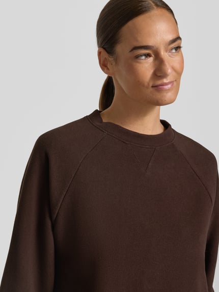 Kobieta nosi Relaxed Fit Sweatshirt aus Baumwoll-Mix od s.Oliver RED LABEL w kolorze brązowym, widok z przodu, zbliżenie na górną część ciała.