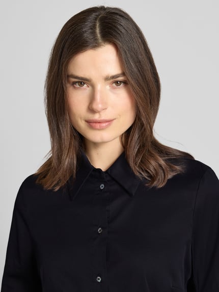 Kobiece modelka nosi Hembluse mit 3/4-Arm mit Aufschlag od Marc Cain w kolorze czarnym, bawełniano-wiskozowa mieszanka ze stretchem, prosty krój, kołnierz koszulowy, zapięcie na guziki, długość tyłu 59 cm, długość rękawa 42 cm, zbliżenie na górną część ciała, przód