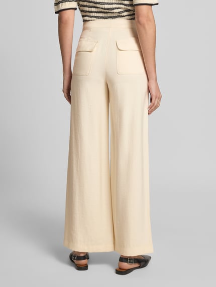 Frauenmodel trägt Wide Leg Hose aus Modal-Mix von Jake*s Casual in Creme mit Gesäßtaschen und Knopf, Ganzkörperansicht Rückansicht. Bundweite bei Größe 36: 35 cm, Innenbeinlänge: 79 cm.