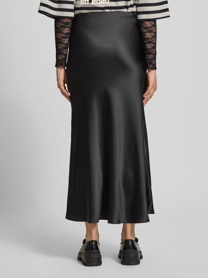 Frauenmodel trägt Satinrock mit elastischem Bund von Gina Tricot in Schwarz, Gerader-Schnitt, Maxi, Satin-Haptik, Ganzkörperansicht Rückansicht.