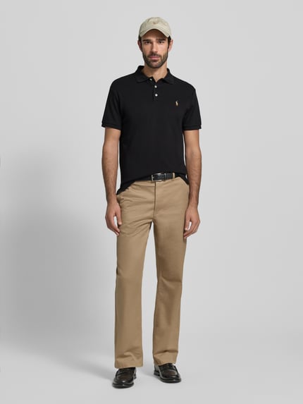 Männermodel trägt Poloshirt mit Label-Stitching von Polo Ralph Lauren in Schwarz, Reine Baumwolle, Regular-Fit, Ganzkörperansicht von vorne.