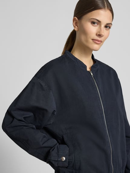 Modelka nosi Jacke aus Baumwoll-Leinen-Mix mit Reißverschluss von Lanius, kolor granatowy, krój regular fit, zamek błyskawiczny, stójka, mieszanka bawełny i lnu, szerokość ramion w rozmiarze 36: 43 cm, szerokość klatki piersiowej w rozmiarze 36: 56 cm, długość rękawów: 62 cm, długość tyłu: 58 cm, zdjęcie z przodu, zbliżenie na górną część sylwetki.