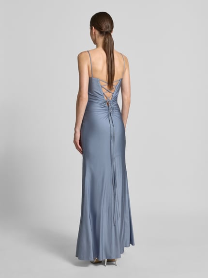 Frauenmodel trägt Abendkleid mit rückseitiger Schnürung und Gehschlitz von Mascara aus Satin in Blau, Maxikleid, Körpernaher-Schnitt, Drapierungen, Spaghettiträger, Rückenlänge 119 cm, Brustweite 31 cm, Ganzkörperansicht Rückansicht.