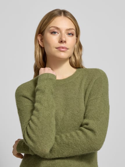 Vrouwenmodel draagt Strickpullover mit Rundhalsausschnitt Modell 'Festina Hope' van MSCH Copenhagen, groene kleur, alpacamix, regular fit, close-up bovenlichaam.
