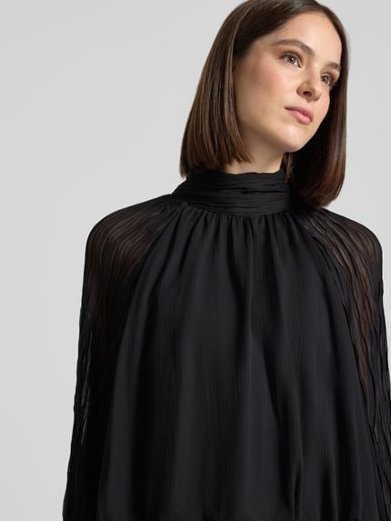 Vrouwenmodel draagt Blusenshirt met Stehkragen Model 'OLERA' van YAS in zwart, regular fit, vloeiende stof, Nahaufnahme Oberkörper, ruglengte maat 36: 45 cm, mouwlengte maat 36: 75 cm.