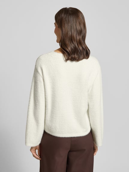 Frauenmodel trägt Oversized Strickpullover mit überschnittenen Schultern Modell 'FEATHER' von Tom Tailor Denim in Creme, unifarben, Feinripp, Rundhals, Ganzkörperansicht Rückansicht.