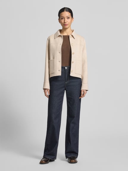Vrouwenmodel draagt Jacke aus Lanawolle mit opgestikte zakken van Milano Italy, zuiver lanawol, regular fit, platte kraag, knoopsluiting, ruglengte maat 36: 56 cm, schouderbreedte maat 36: 41 cm, borstwijdte maat 36: 53 cm, mouwlengte maat 36: 62 cm. Volledige lichaamsaanzicht van voren.