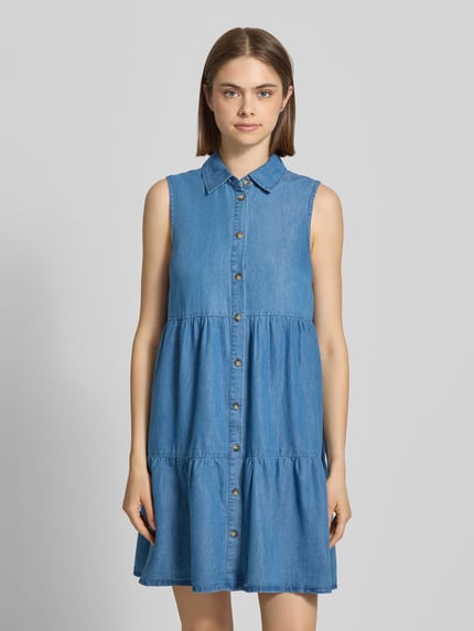 Vrouwenmodel draagt uitlopend denimjurk uit mix van katoen en lyocell, knielang, hooggesloten, knoopsluiting, model 'BEA SIESTA' van Only, denimlook, mouwloos, voorkant, bustenopname.