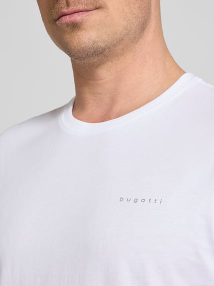 Männermodel trägt T-Shirt mit Label-Detail von bugatti in Weiß, reine Baumwolle, gerader Schnitt, Nahaufnahme Oberkörper.