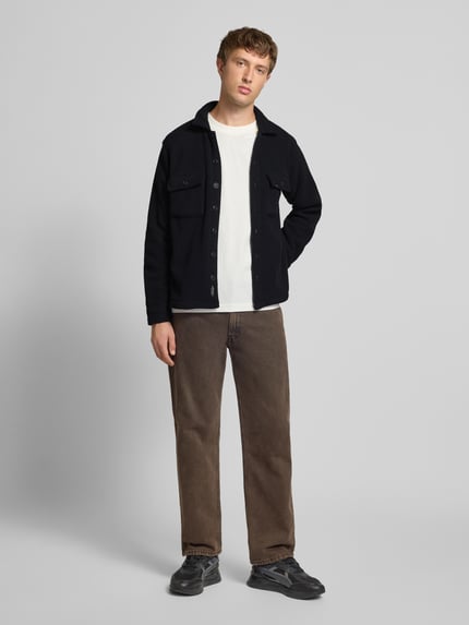 Mannelijk model draagt Regular fit vrijetijdsoverhemd met Kentkraag Model 'BAKI' van Blend, fleece materiaal, borstzakken, knoopsluiting, in zwart, gecombineerd met bruine broek en sneakers, context: ruglengte maat M 68 cm, schouderbreedte 46 cm, mouwlengte 64 cm; geheelbeeld van voren.