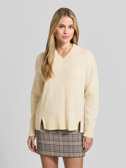 Frauenmodel trägt Pullover Modell 'Zinnia-Top-CloudCashmere' von Joseph in Uni-Strickoptik mit V-Ausschnitt und Seitenschlitzen, Ganzkörperansicht von vorne.