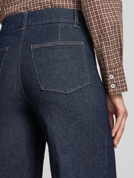 Frauenmodel trägt Wide Leg Jeans mit Ziernähten Modell 'PALOMA' von MANGO, dunkles Denim, sichtbare Gesäßtasche, Detailaufnahme, Damen Wide Fit, Haken- und Reißverschluss, seitliche Eingrifftaschen, Ziernähte, KI-modifiziertes Bild.